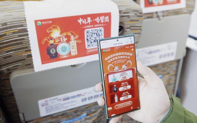 春运高铁座椅头枕巾广告-旅客正在扫描参与活动