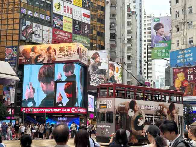 香港铜锣湾街景大屏大牌公交车身以及密集人流都在为姜涛庆生