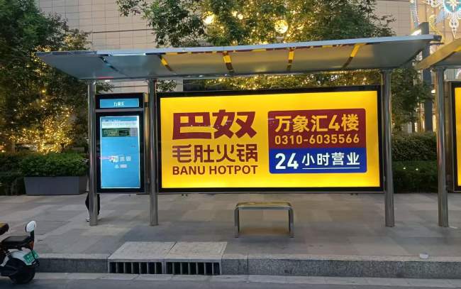 邯郸万象汇外明黄底色的巴奴毛肚火锅公交站亭广告 