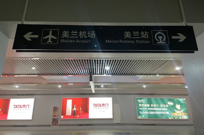 美兰站换乘通道内指示牌悬挂在通道上方，指示着机场和高铁站的方向