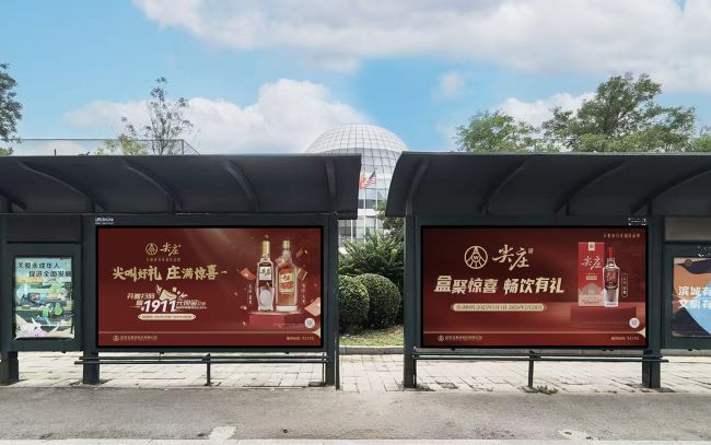 天津候车亭广告刊登着尖庄酒，大红色喜庆的广告画面 