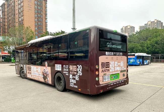 清远公交210A路停靠在城北客运站公交场站内，车身刊登着侧田演唱会宣传信息