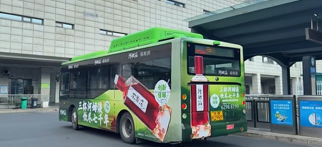 余姚北站公交场站内，公交车身搭载河姆液酒行驶中