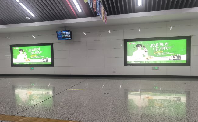 青年大街地铁站站厅层，海天味业携手代言人周深在墙面灯箱广告上与市民见面