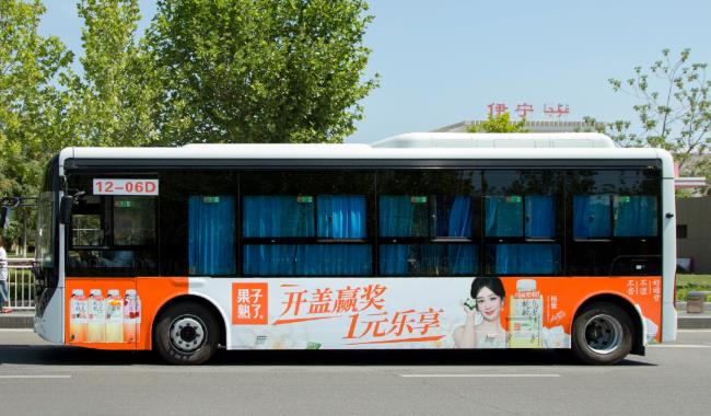 杨紫代言的果子熟了饮料，橙黄色的公交车身广告上刊伊宁公交12路，图为伊宁站前实拍图