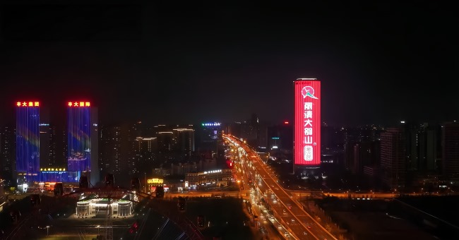 金寨路与繁华大道交口，合肥文峰中心灯光秀在夜间熠熠生辉，图为航拍视角照片 