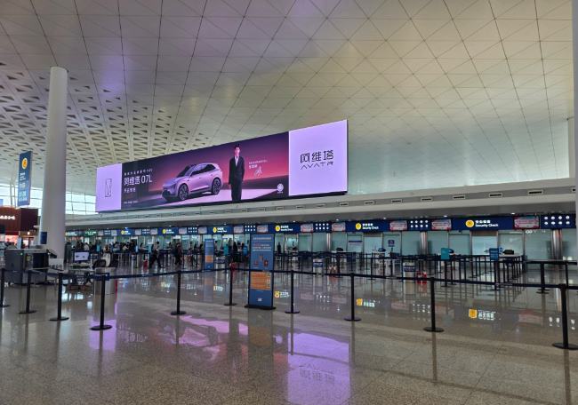图为武汉天河机场T3航站楼4层出发大厅日间场景实拍图，A区安检口空闲场景，图中阿维塔汽车亮屏LED巨幕张凌赫代言