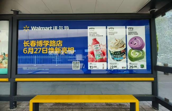 长春沃尔玛新店开业，选择周边公交车站广告牌进行产品宣传，图为长春博学路站周边站点