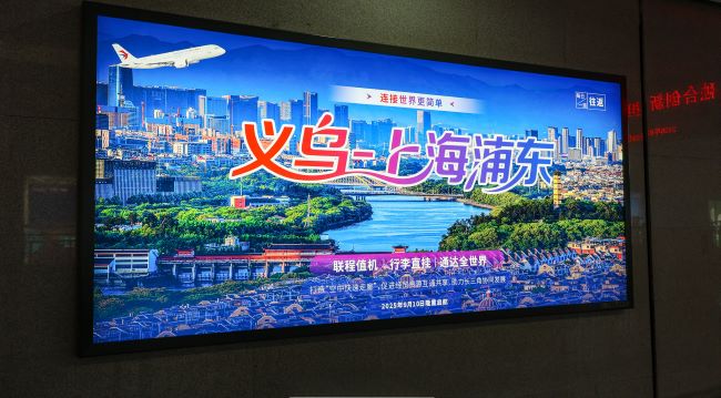 图为义乌火车站通道墙面展示的公益广告，义乌-上海浦东空铁联运