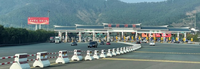 图为祥谦收费站周边场景实拍图，左侧是高杆立柱大牌广告，右侧是中石化加油站