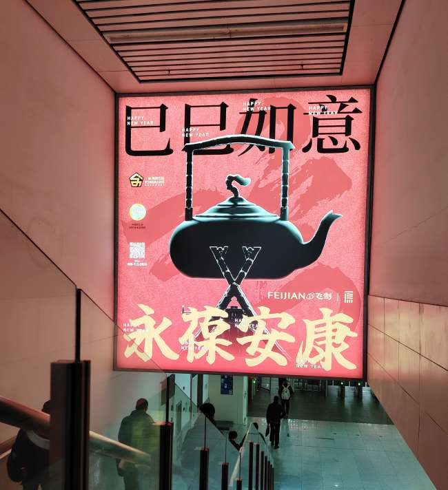 永康被誉为“中国杯壶之都”，全世界90%以上的保温杯都来自这里，图为永康南高铁站出站到达区域的飞剑钛合金杯广告