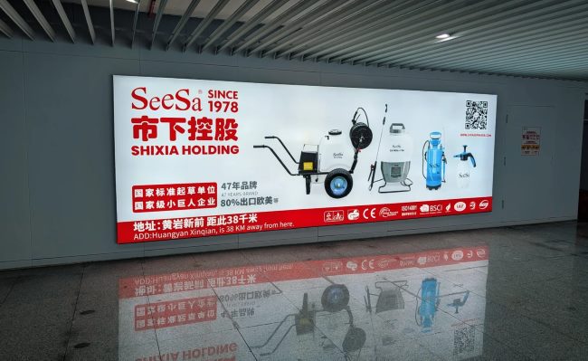 台州机场广告牌市下控股 (SeeSa) 广告：展示“市下控股 SINCE 1978”，画面陈列了手推式打药机、背负式喷雾器、电动喷雾器等植保机械产品。