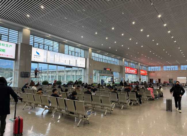 图为乐清站二层候车大厅检票口侧玻璃幕墙实拍图，窗外事乐清卧佛山风景，游客拍照留念